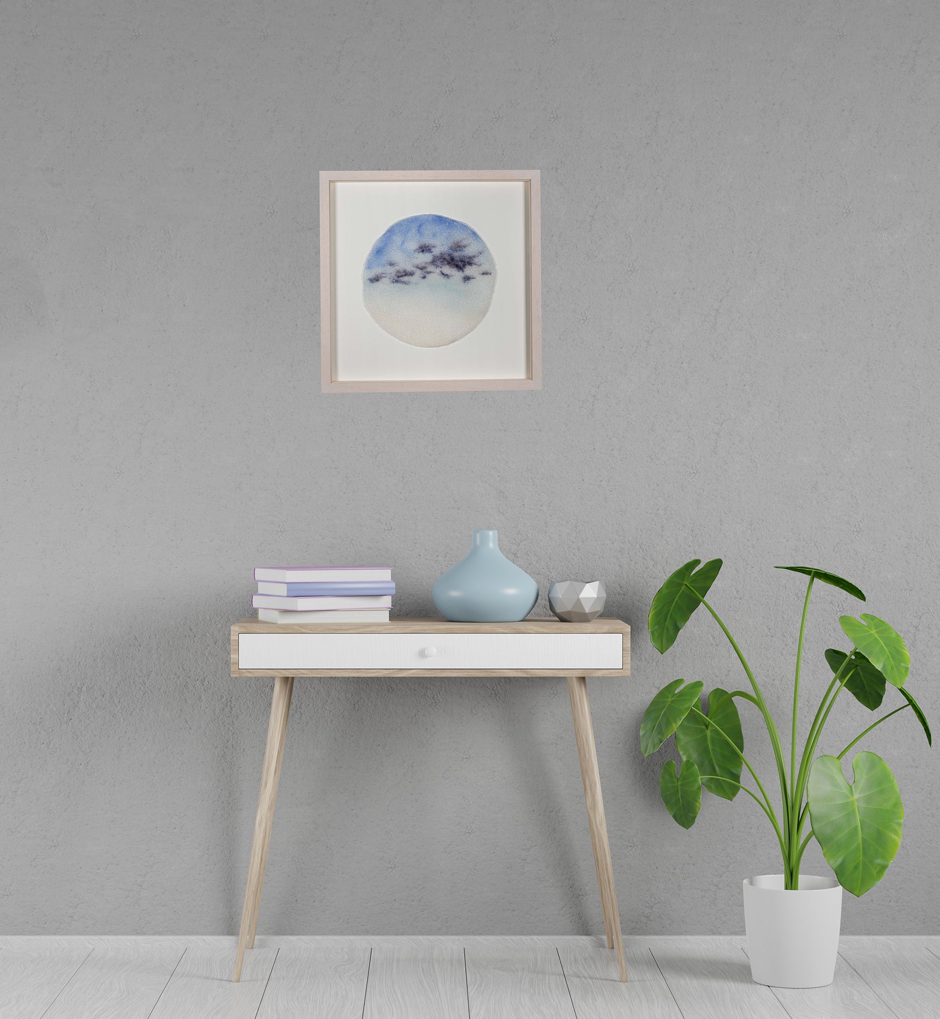 Framed glass artwork by Longwill Studio photographed on the wall in a beautiful interior. The artwork is a disc of fused glass inspired by morning skies